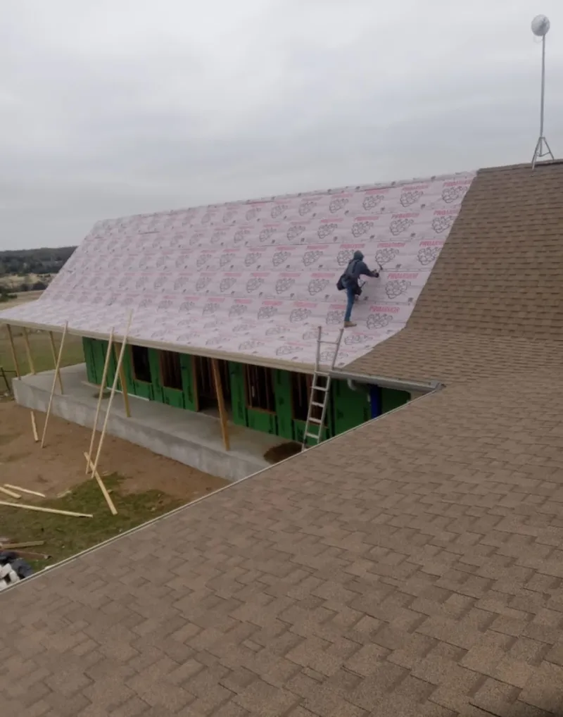 Worker preparing underlayment for a metal roof installation in Wilmore